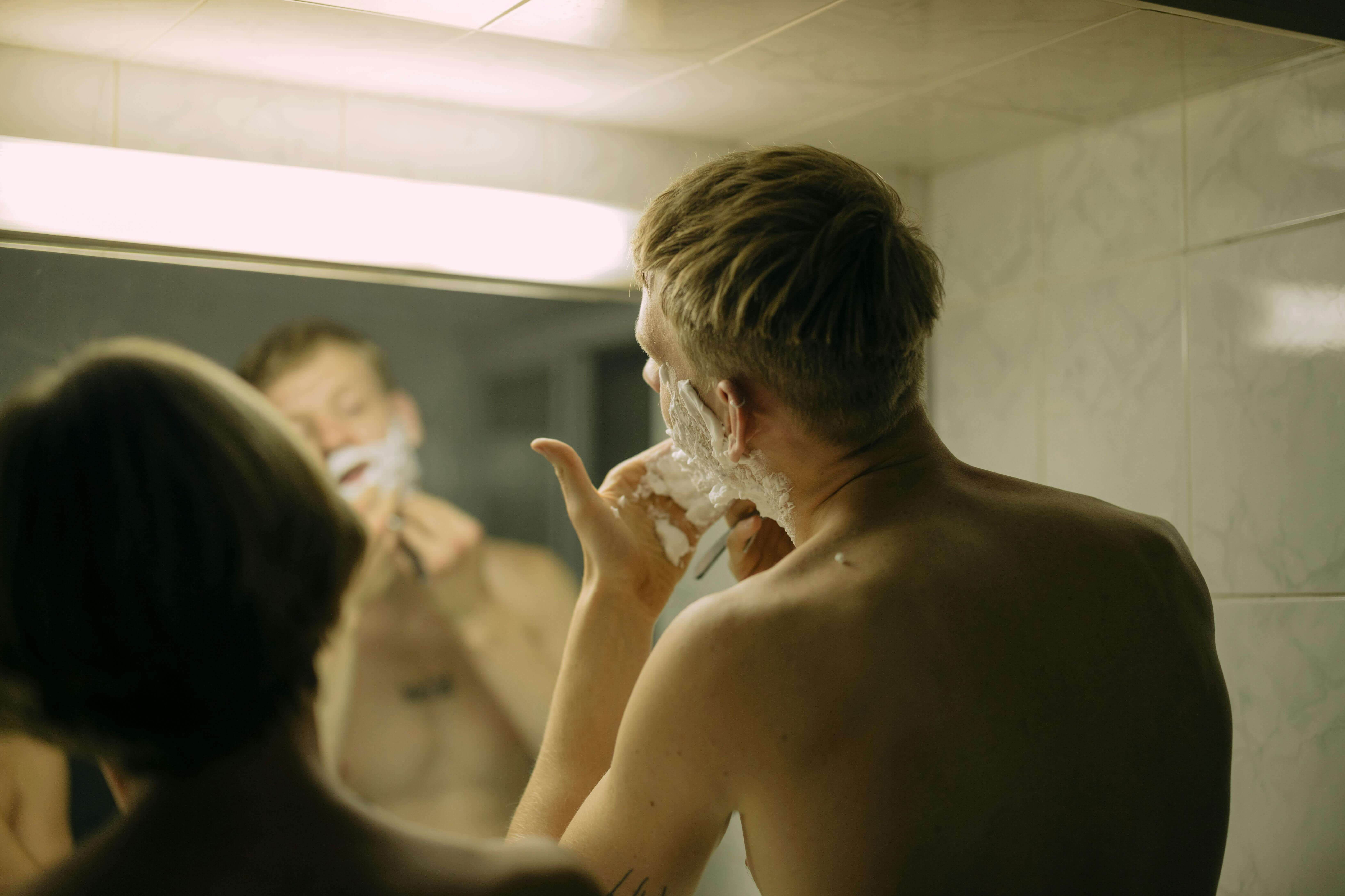 man shaving in front of a mirror