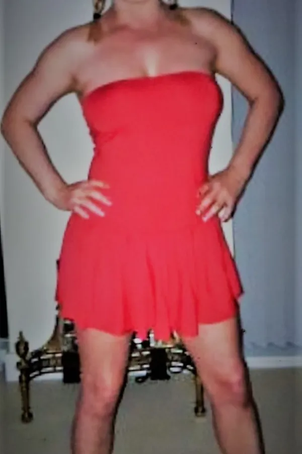 Annalise posing in a red dress showing off her body